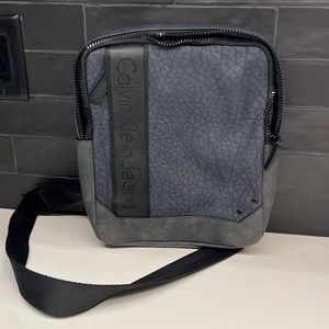 Calvin Klein small bag. Fits standard iPad. Front, interior, and back pockets.